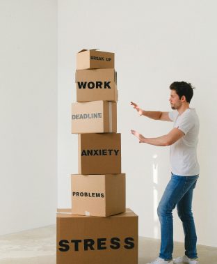 man pushing boxes away, labelled as his stress sources